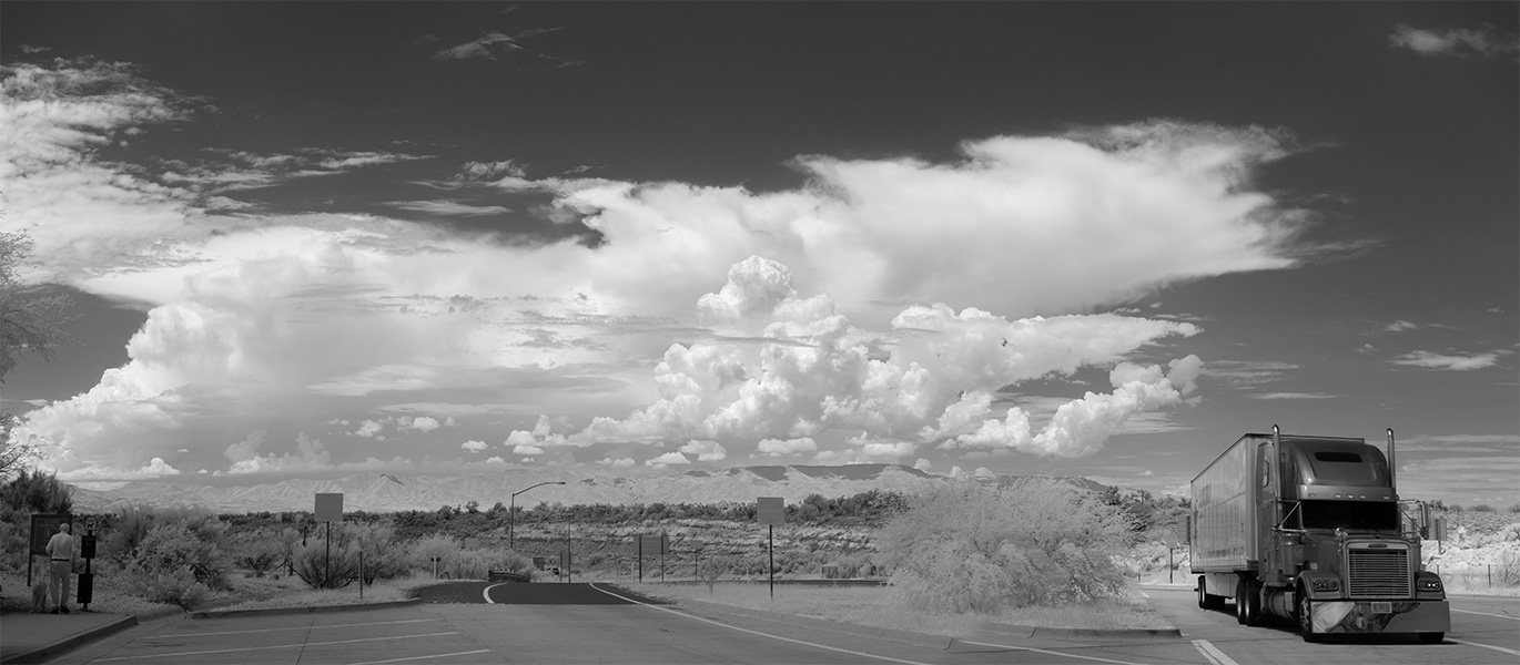 Infrared Panoramic Photo of Parking Area, Big Desert Clouds, and Semi-Truck.